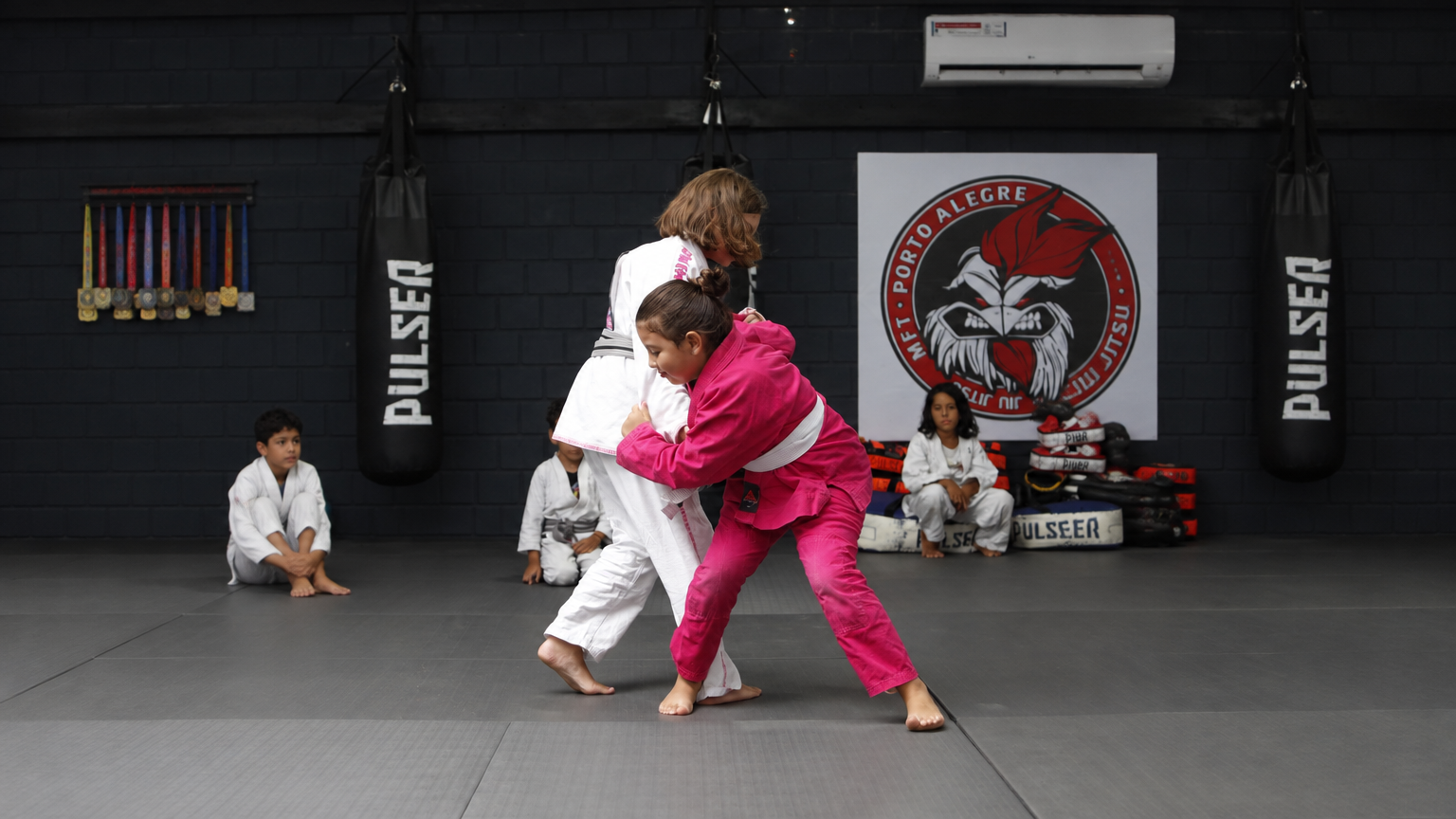 Crianças praticando Jiu-Jitsu em aula
